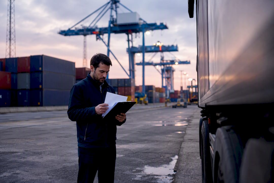 Logistics operator checking carrier invoices outdoors