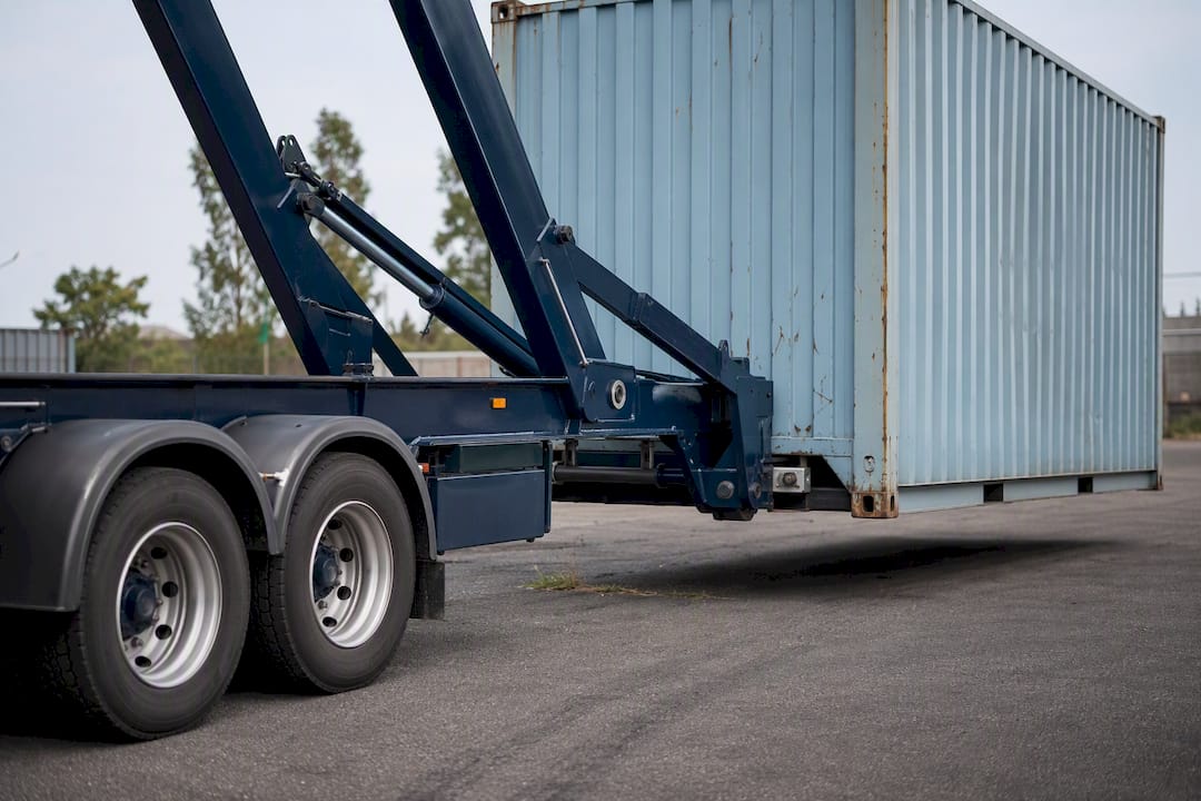 Sidelifter truck lifting container on firm yard