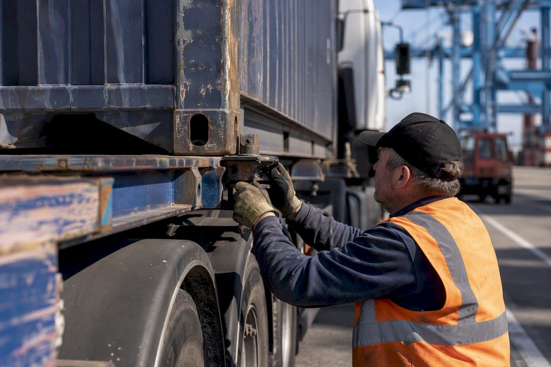 Driver securing container on chassis at UK port yard