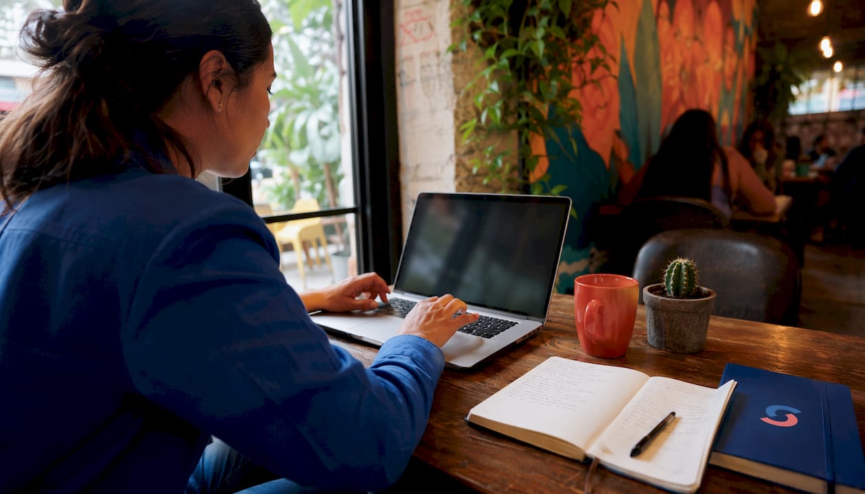 Hands typing on laptop in coworking space