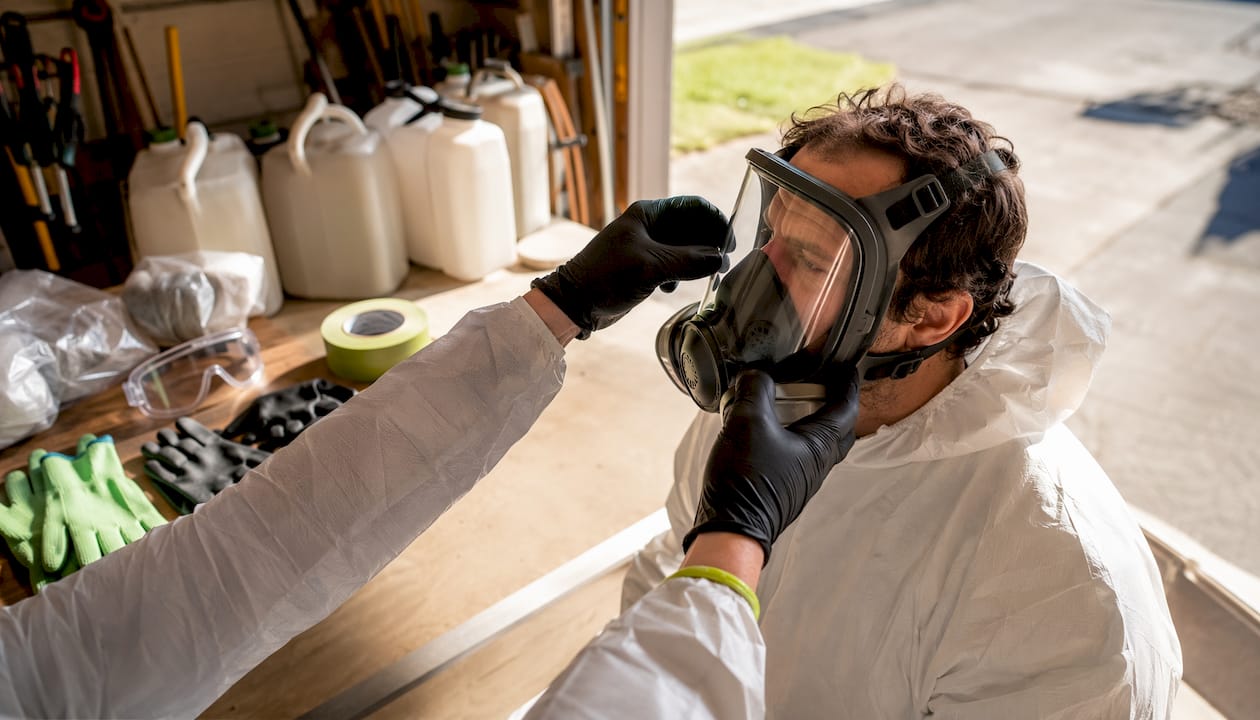 Hands adjusting respirator for foam removal safety