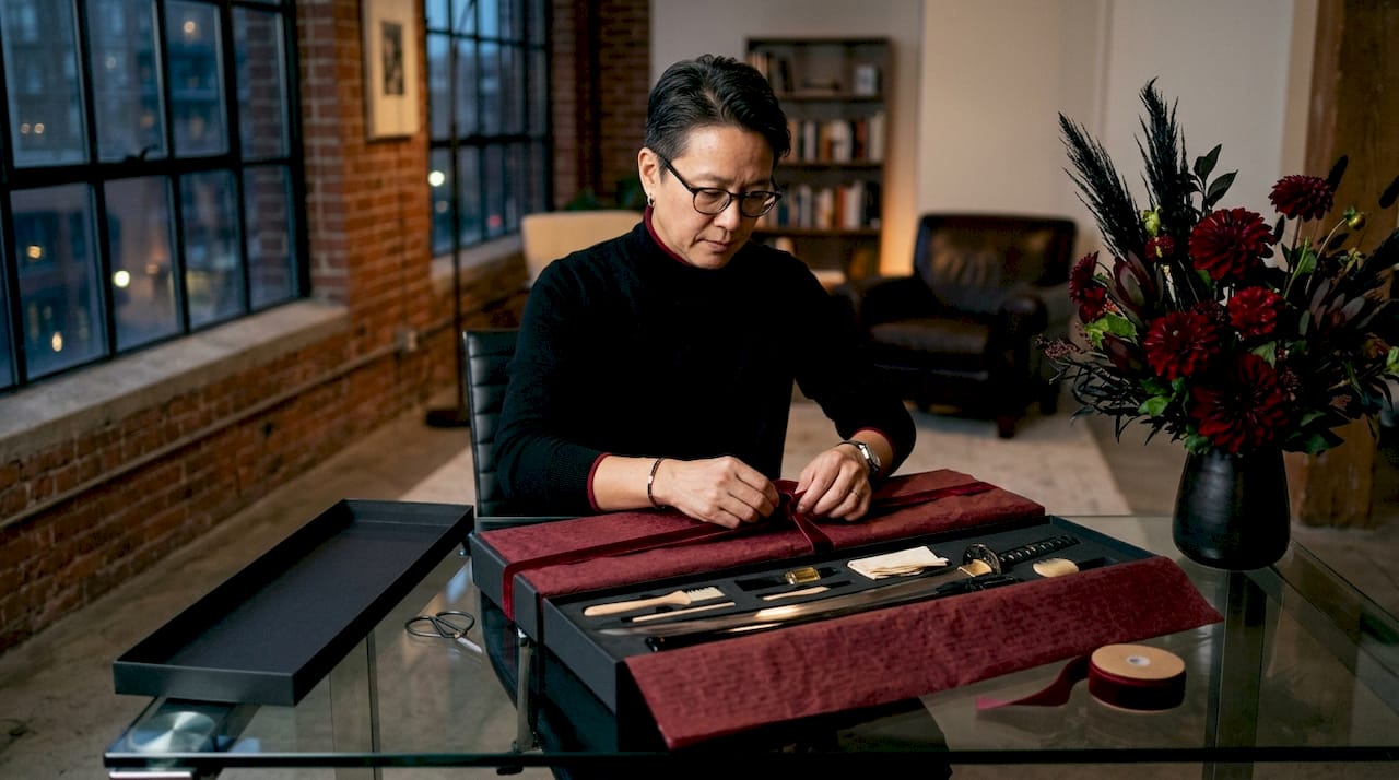 Person assembling katana gift bundle at desk