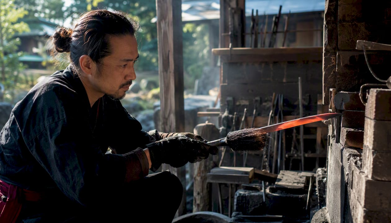 Artisan applying clay tempering to katana blade