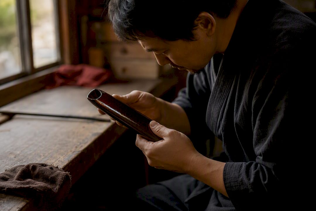 Hands inspecting saya koiguchi and blade fit