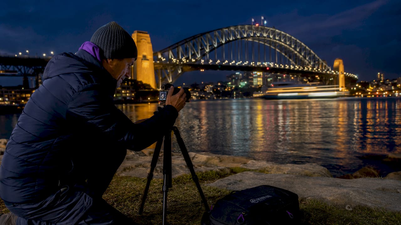 Photographer setting up tripod at Milsons Point nighttime