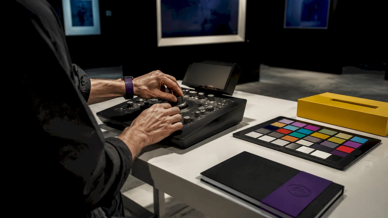 Hands adjusting monitor calibration device on desk