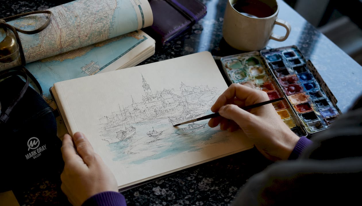 Close-up of hands sketching travel memory