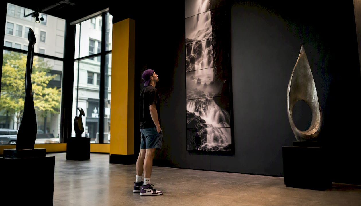 Man observing vertical photo installation outdoors