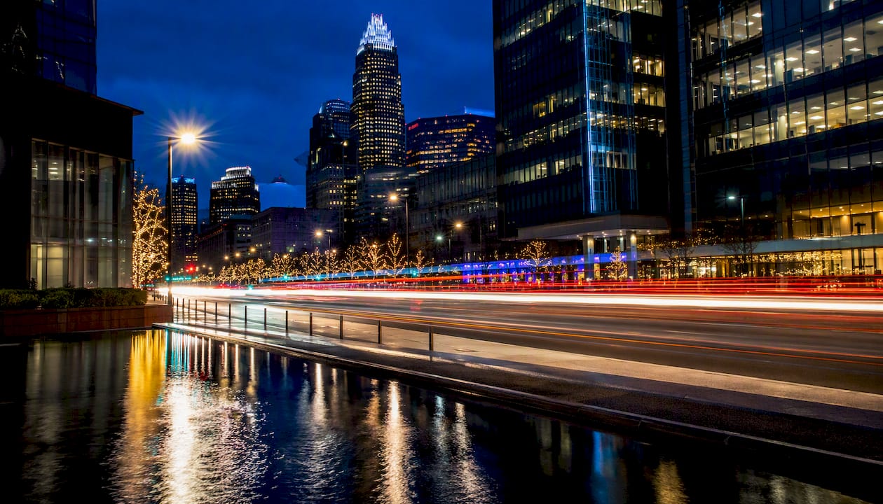 Cityscape with smooth water and light trails at blue hour