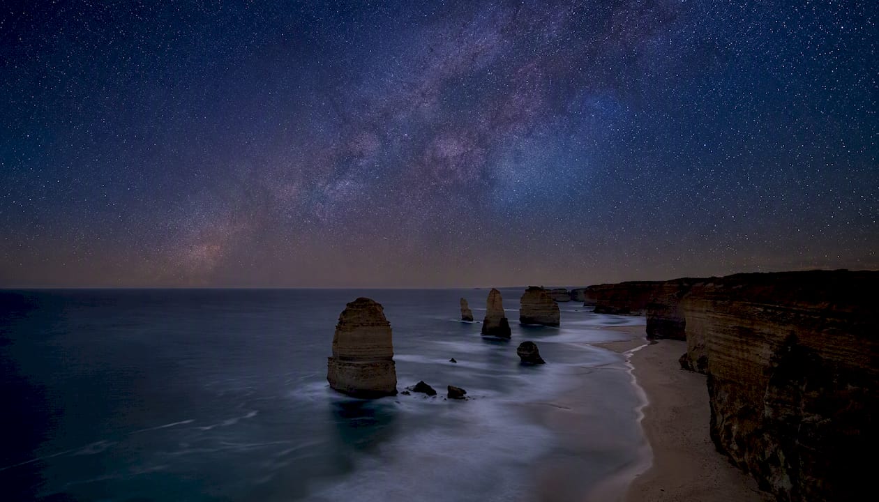Night stars above silhouette of sea stacks