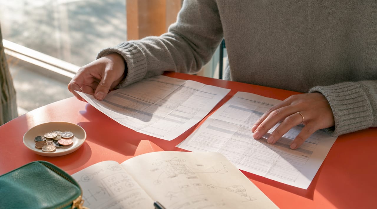 Hands comparing SAT and MCAT registration forms