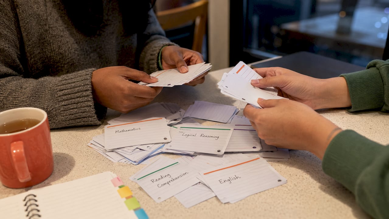 Hands sorting flashcards representing test sections