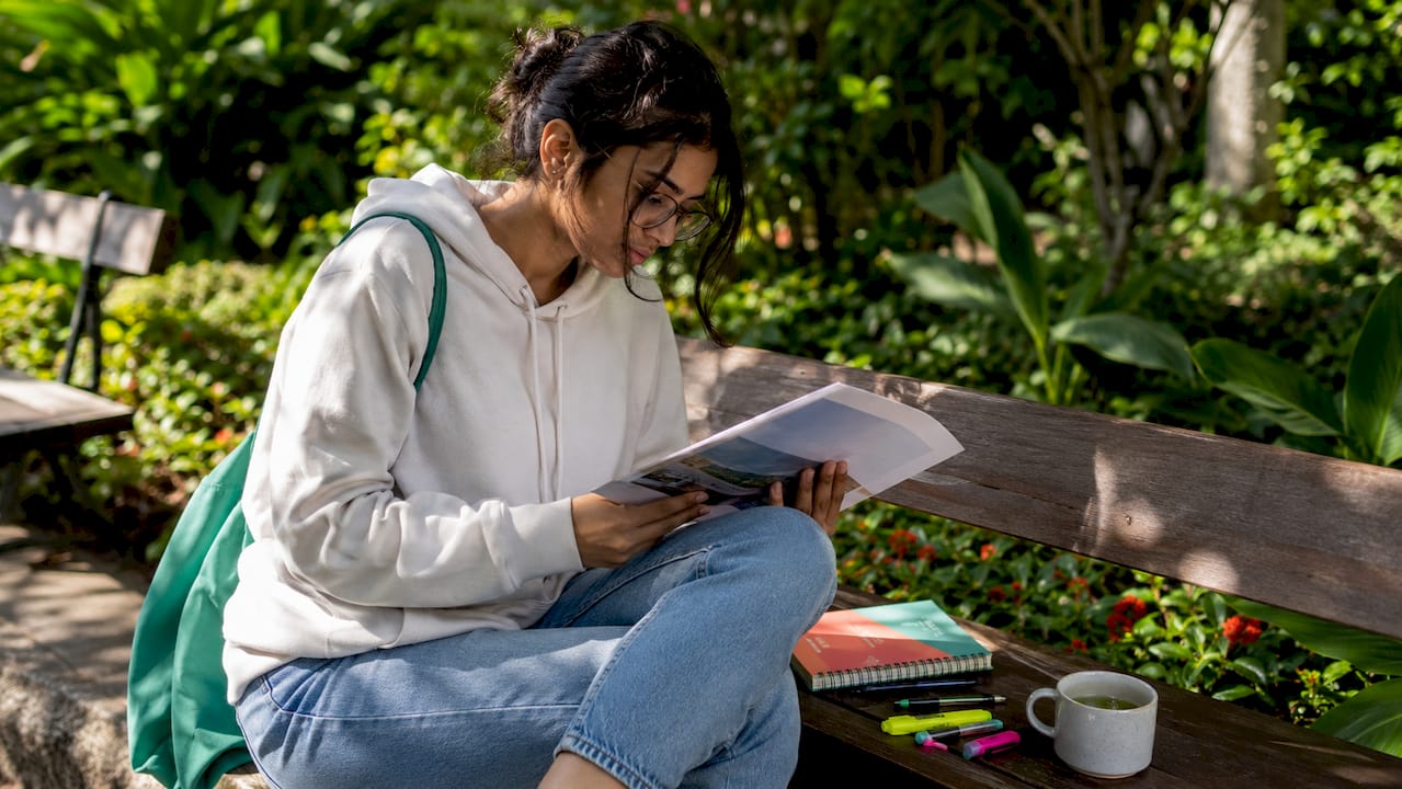 Undergraduate student studying program brochures at library