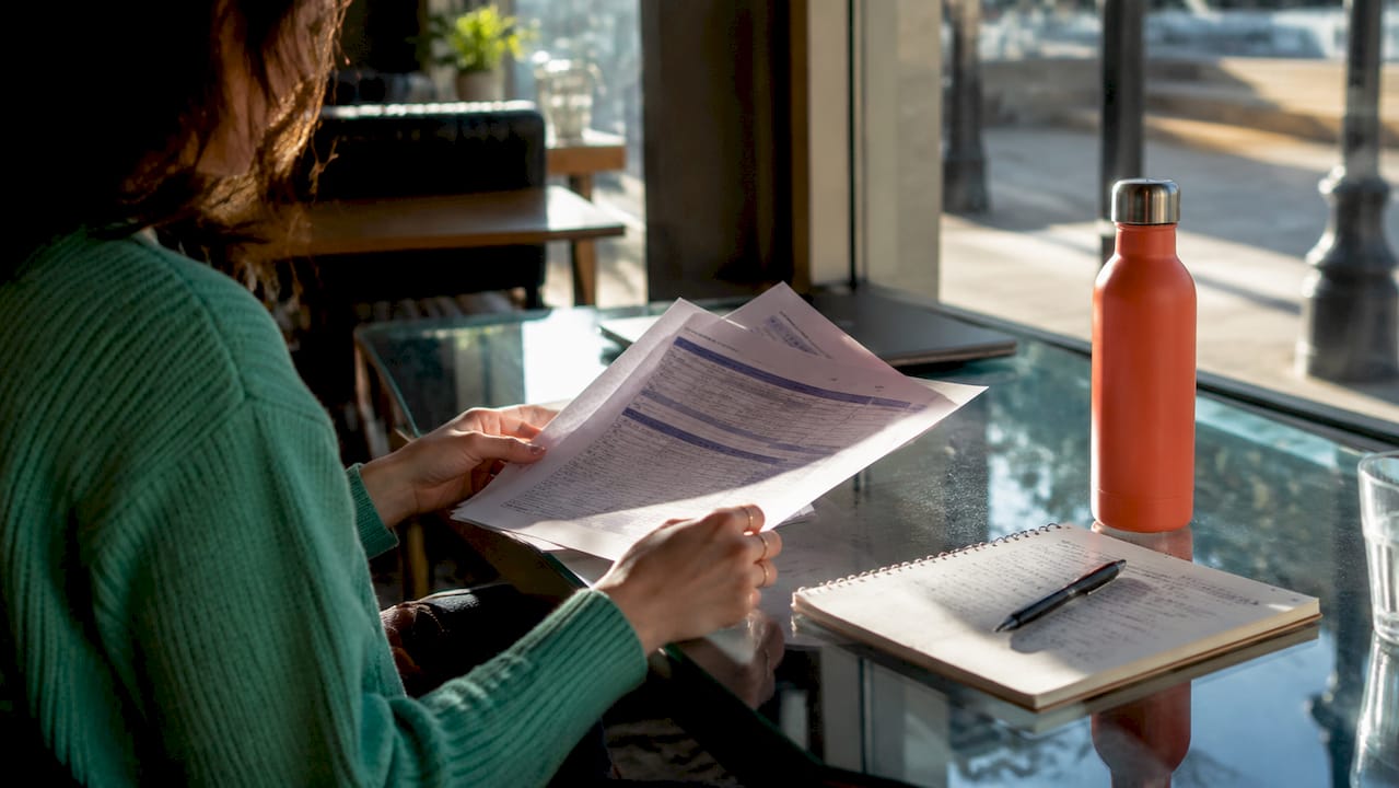Hands holding tuition fee documents with calculator