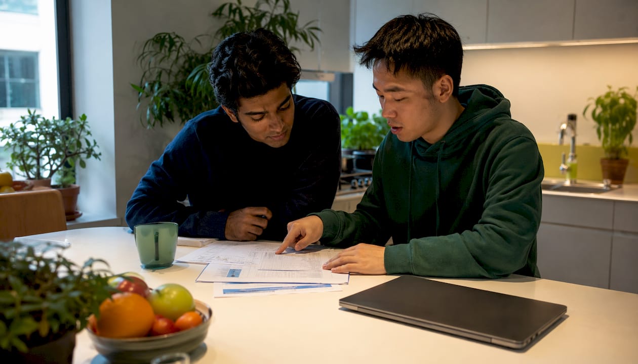 Two students reviewing TOEFL prep materials together