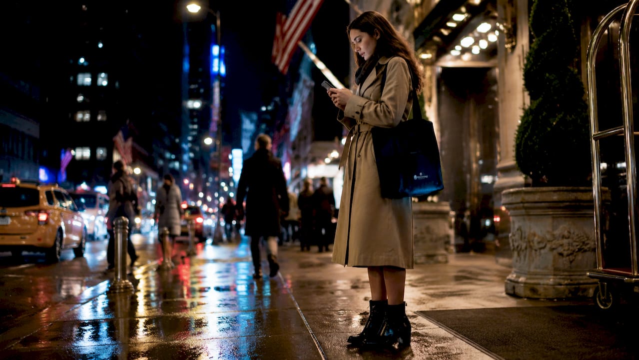 Woman checking hotel booking app outside Times Square hotel