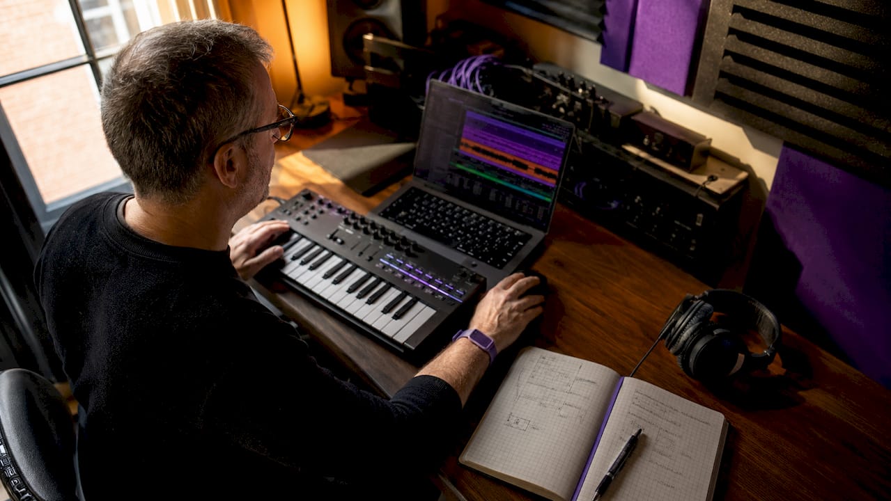 Engineer layering sounds in audio booth at desk