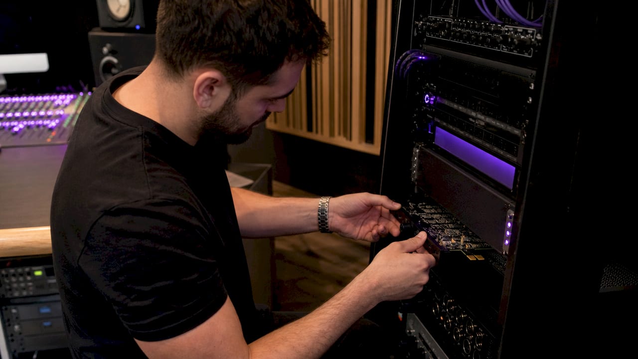 Hands installing AAX DSP hardware in audio rack