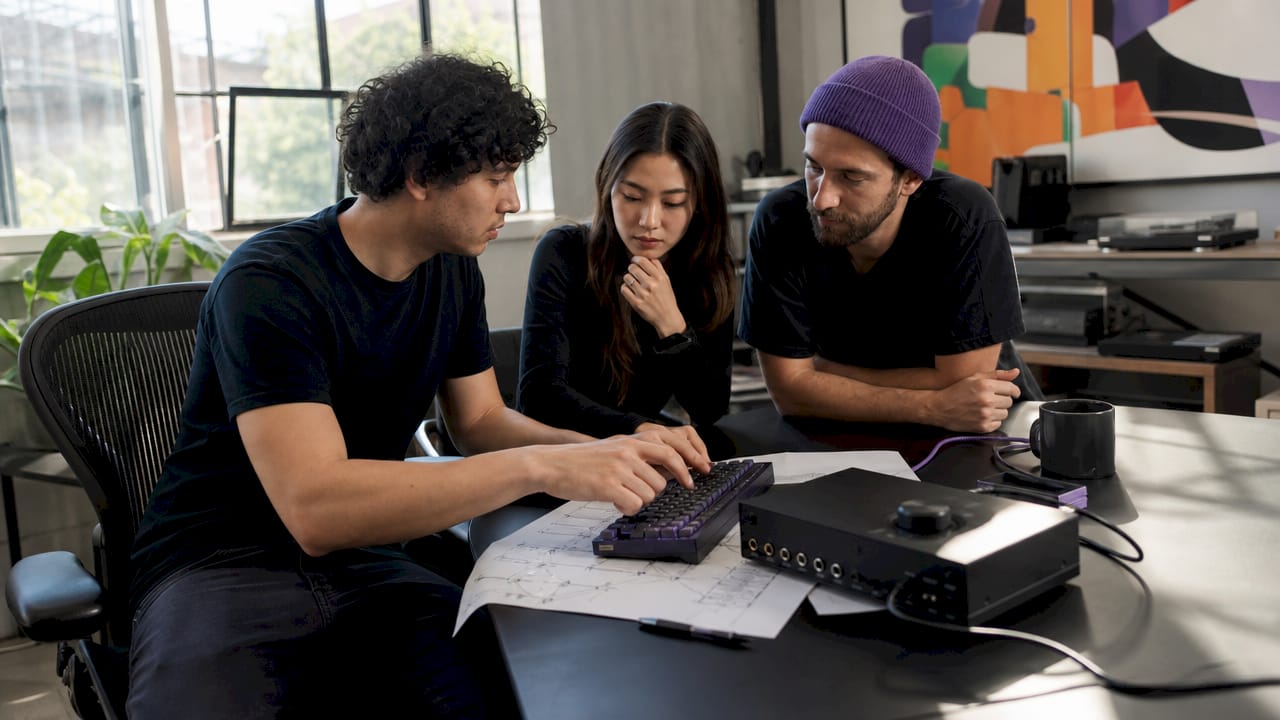 Hands typing near professional audio hardware setup