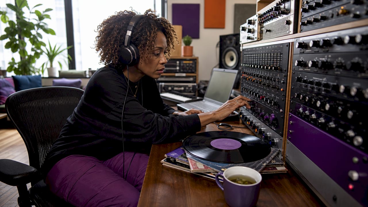 Music producer adjusting analog equalizer in studio