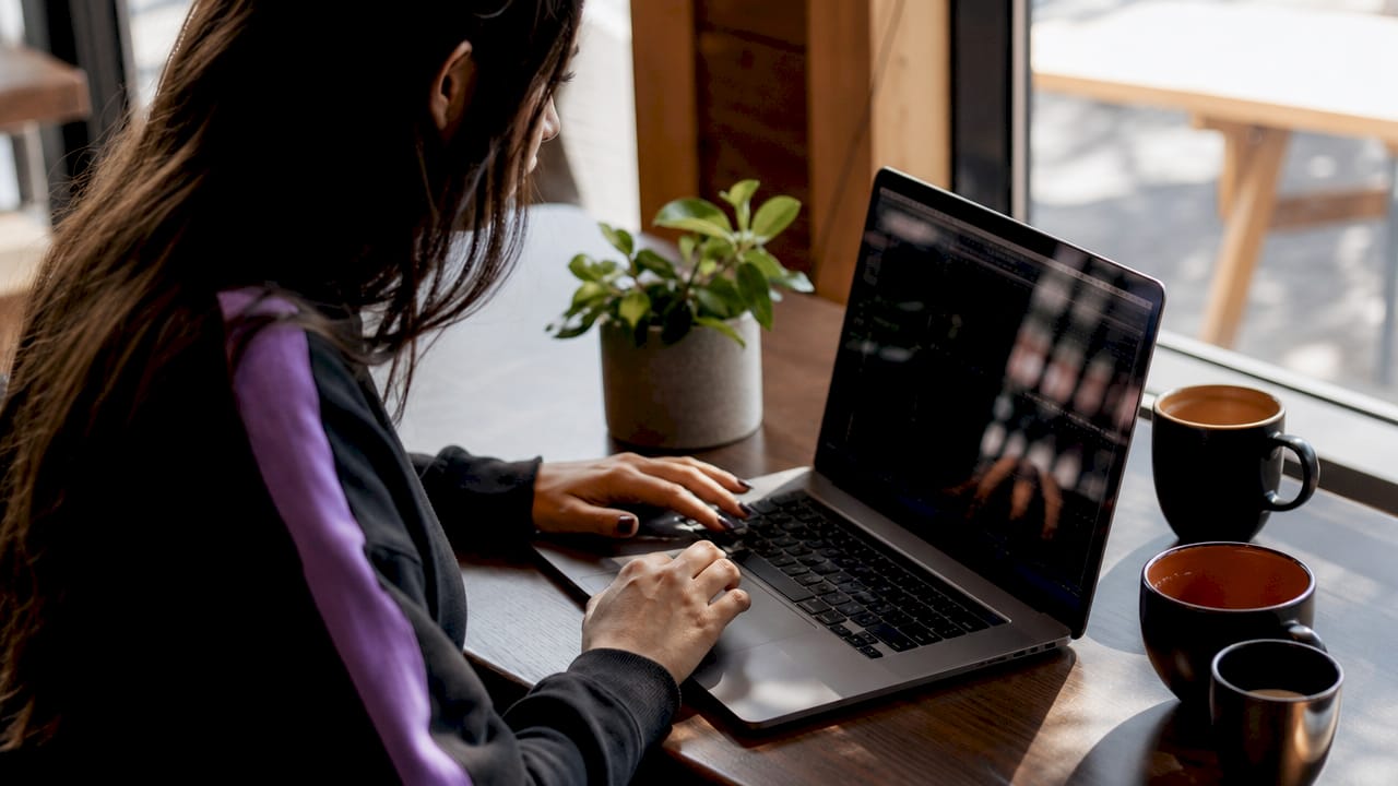Producer managing AAX plugins on laptop keyboard