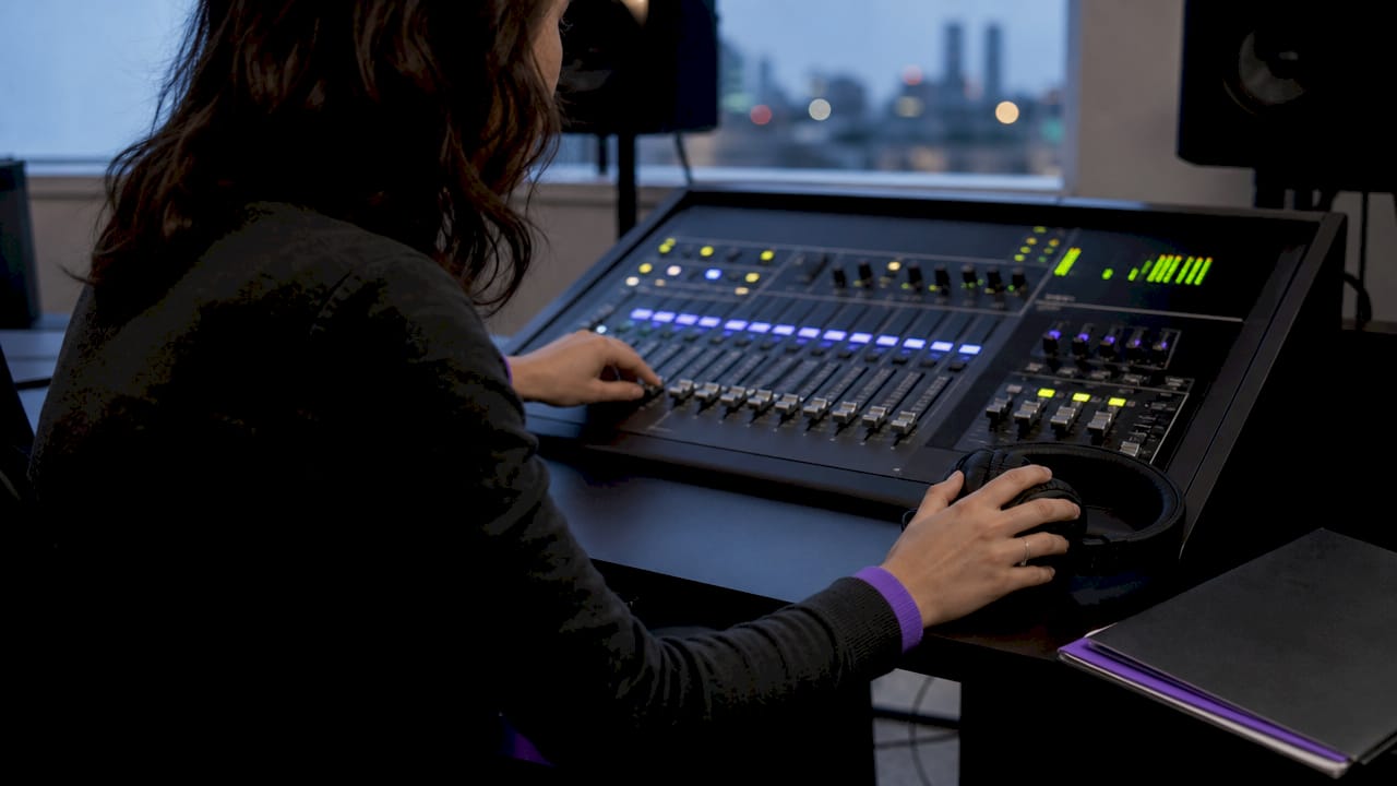 Technician adjusting low latency audio mixer