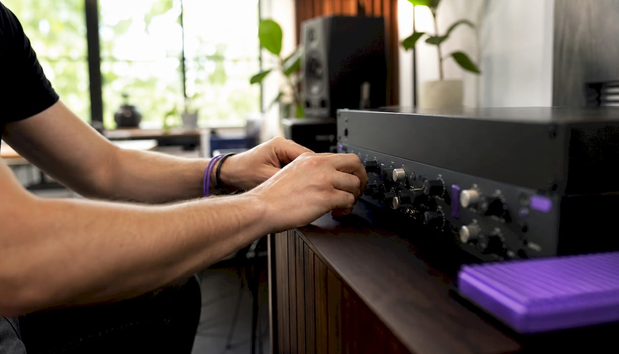 Hands tuning analog-style plugin presets in studio