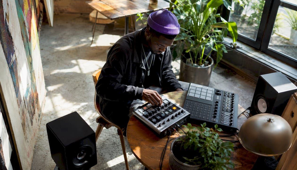 Beatmaker working at drum machine in home studio