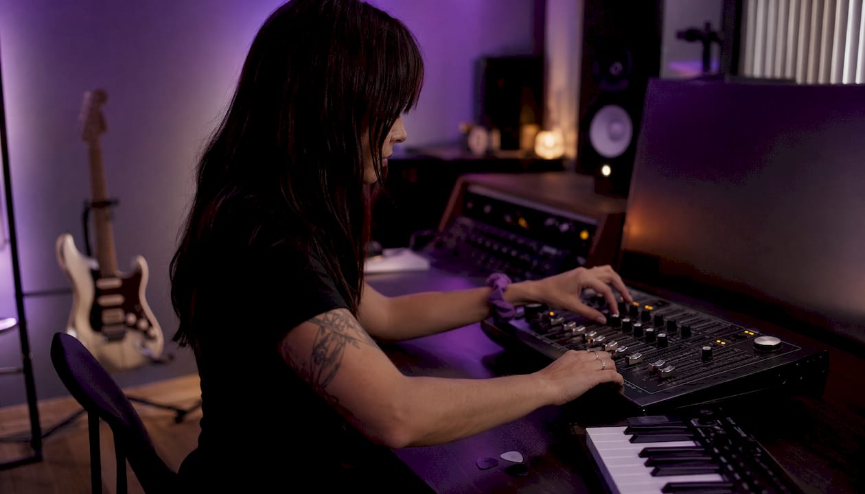 Hands adjusting guitar plugin controls in studio