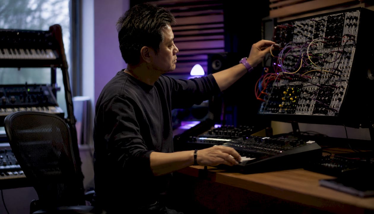 Man patching modular synth in studio