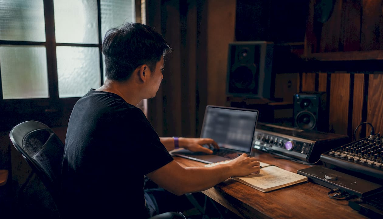 Audio engineer adjusting buffer size on laptop