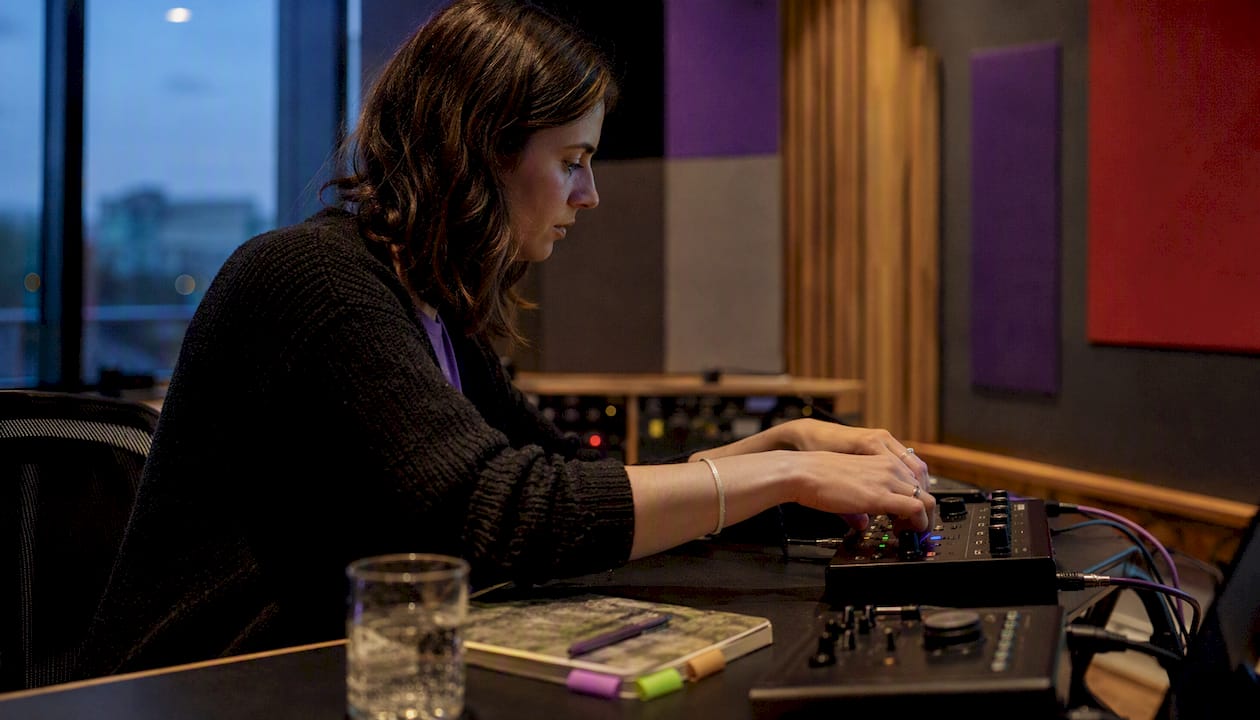 Close-up of hands using audio mixing interface
