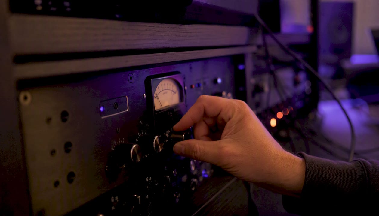Hand adjusting hardware limiter knob in studio