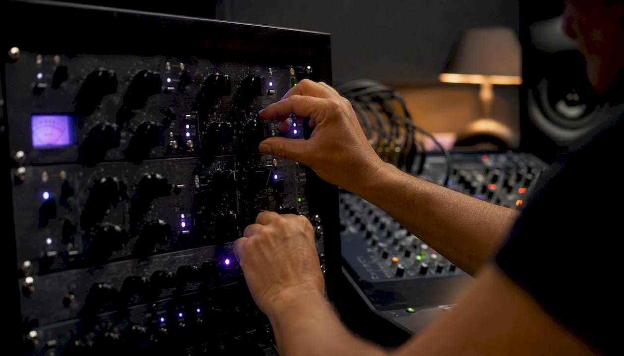 Hands adjusting multiband saturation hardware knobs