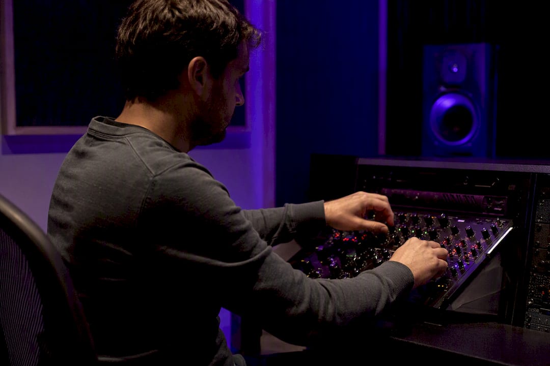 Hands adjusting reverb knobs on audio hardware