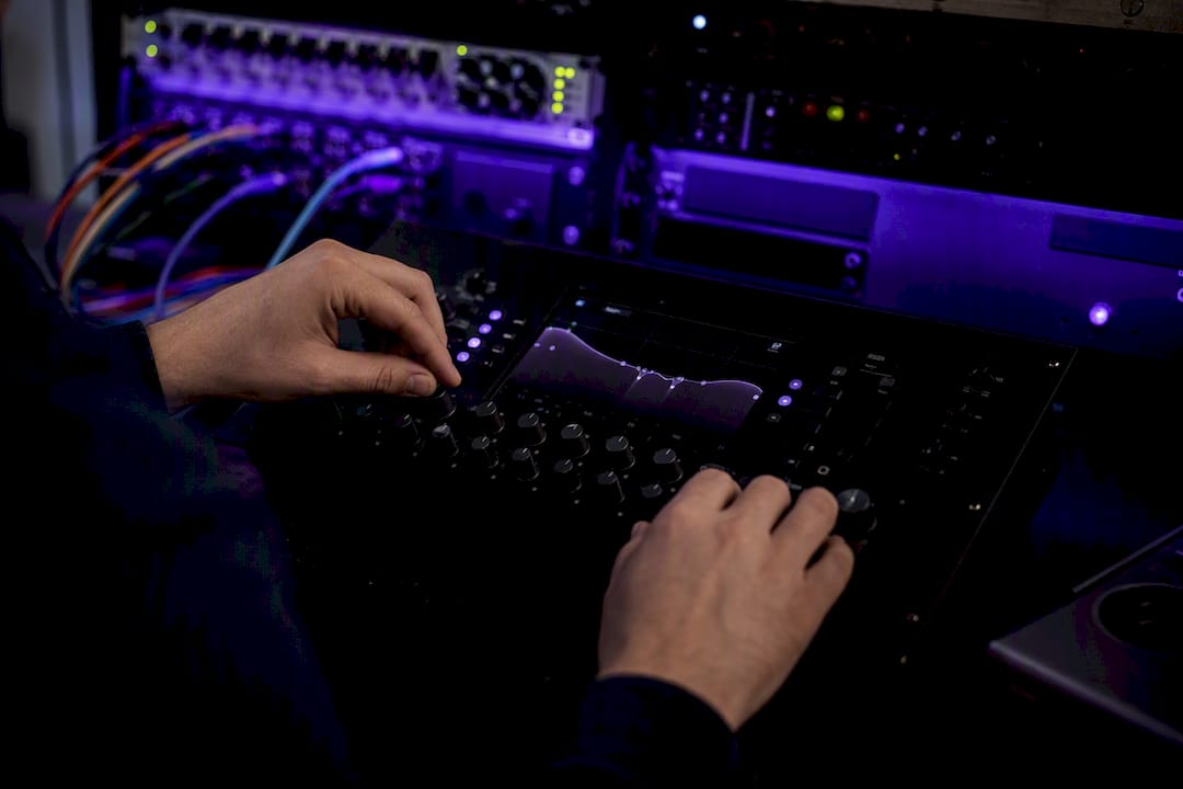 Hands adjusting digital audio equipment knobs