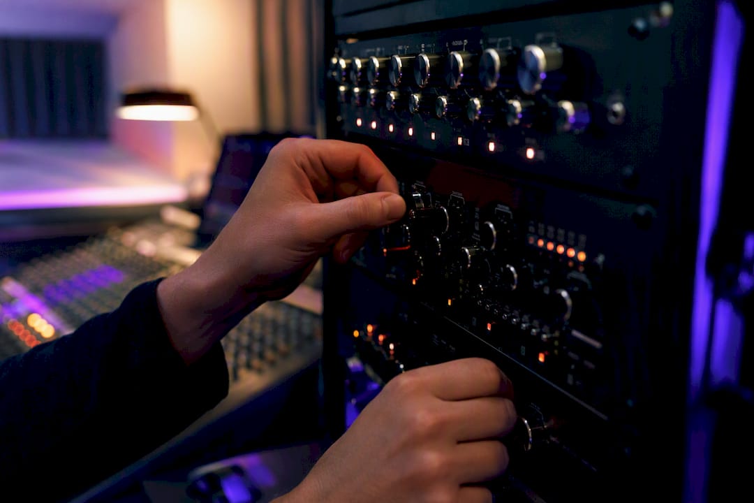 Hands adjusting audio frequency bands on mixer
