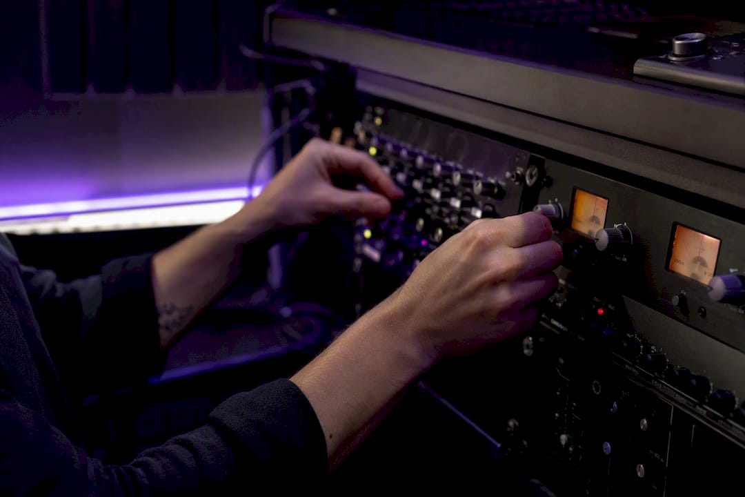 Hands adjusting audio plugin knobs in studio