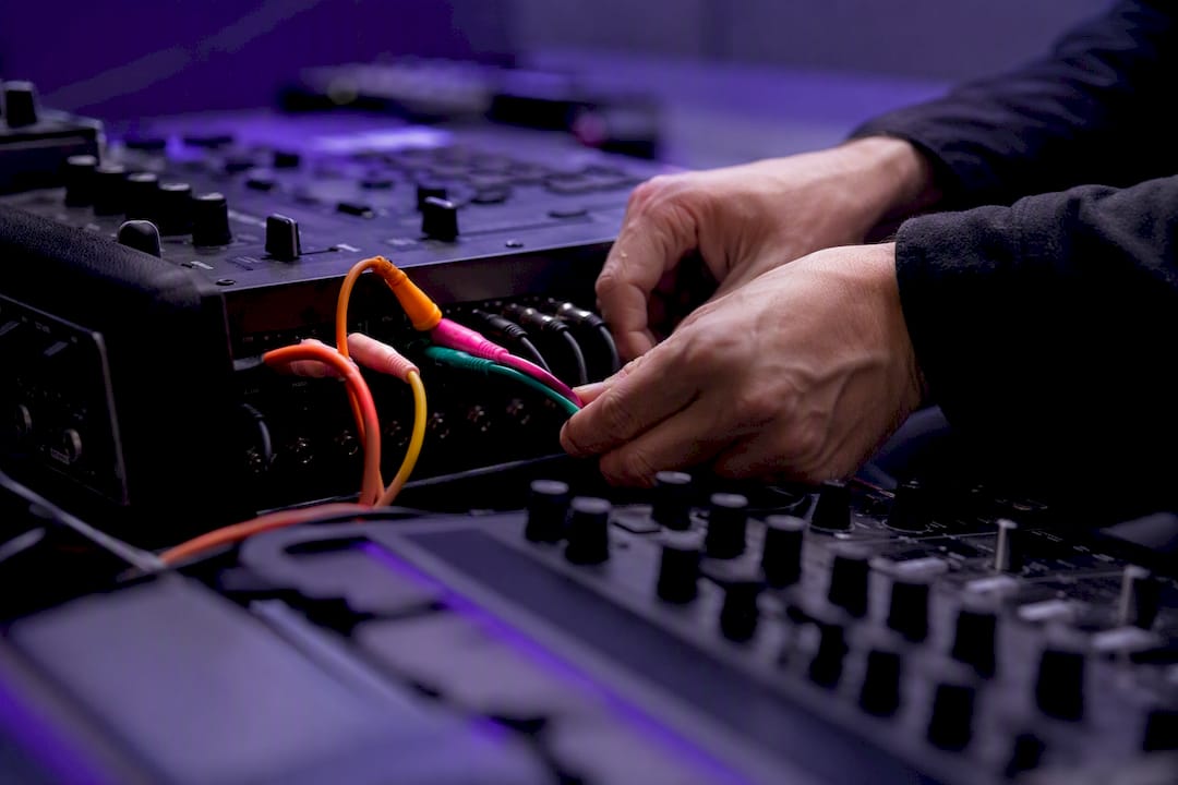 Hands routing drum multi-out cables in studio