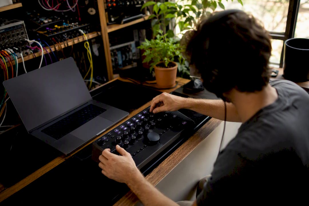 Hands adjusting audio plugin hardware knobs