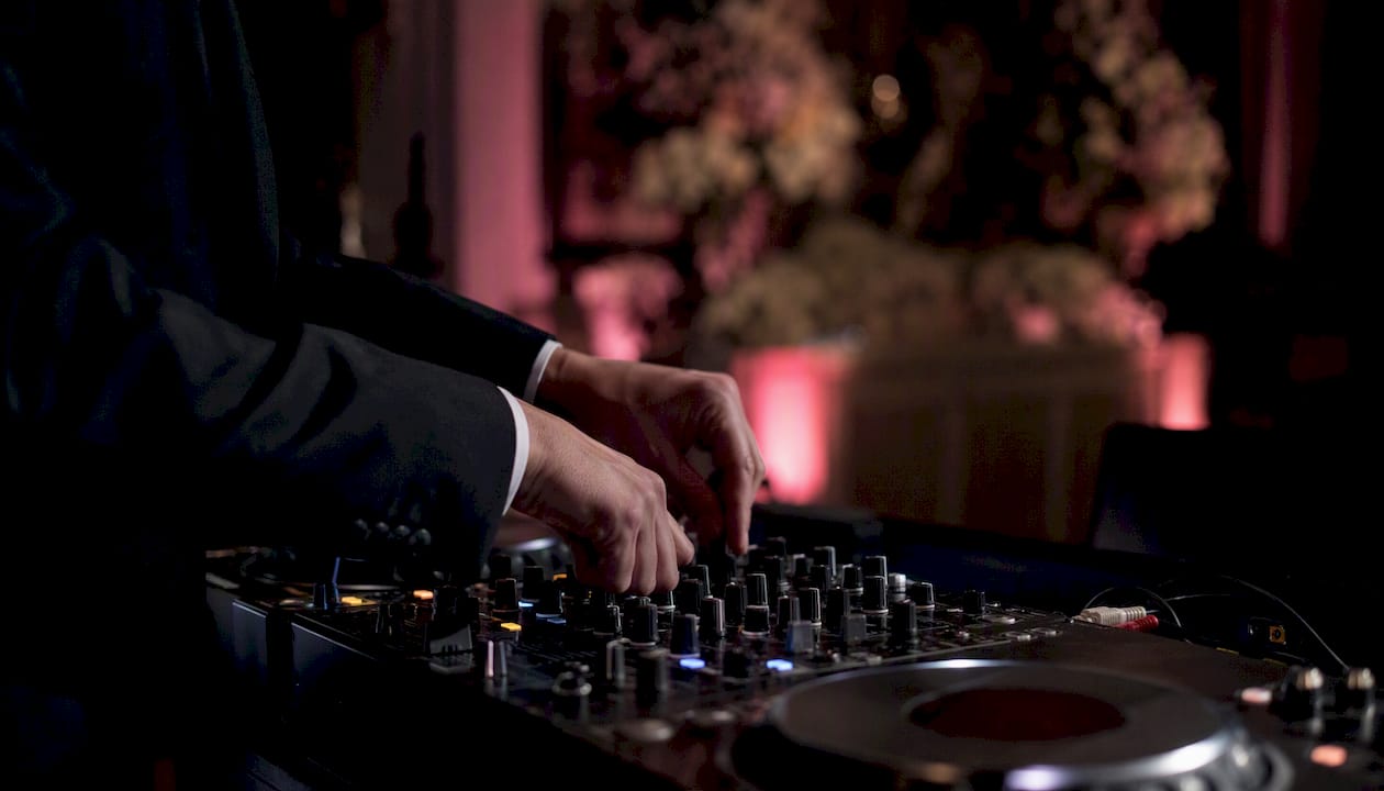 DJ hands adjusting wedding mixer console