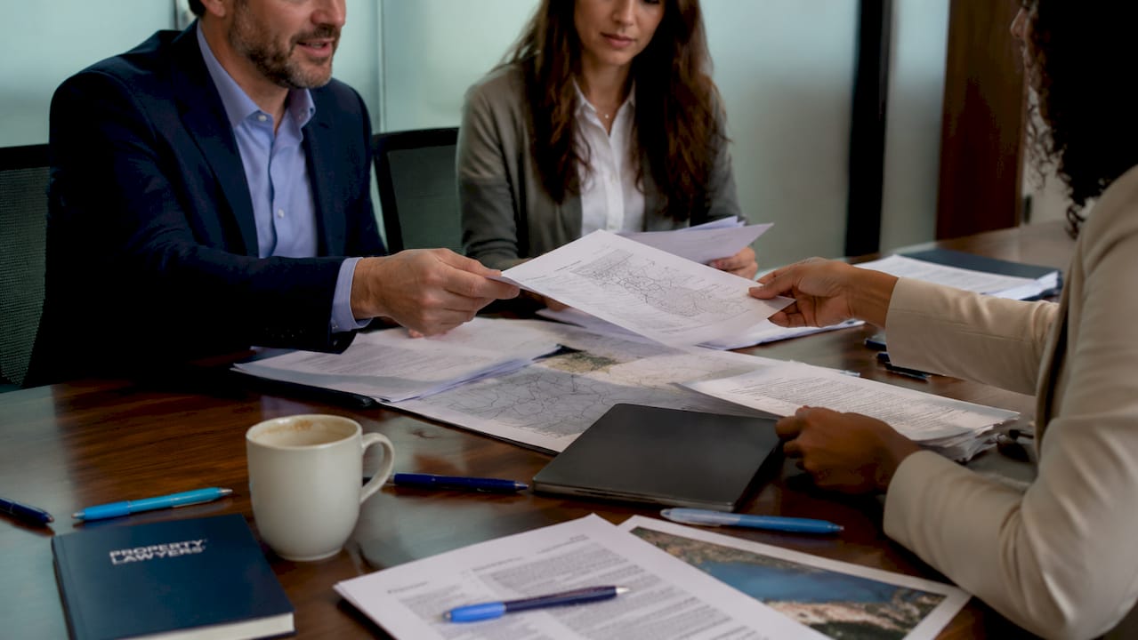 Hands exchanging property due diligence papers