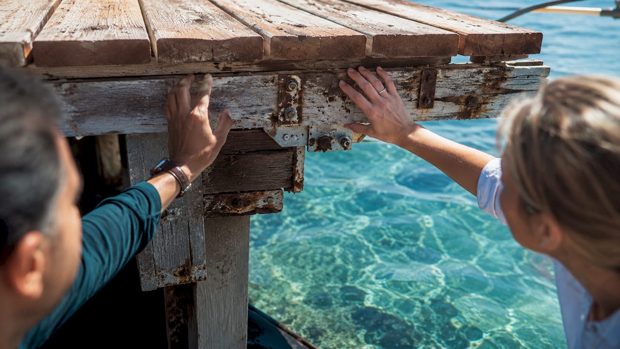 Close-up hands inspecting boat dock durability
