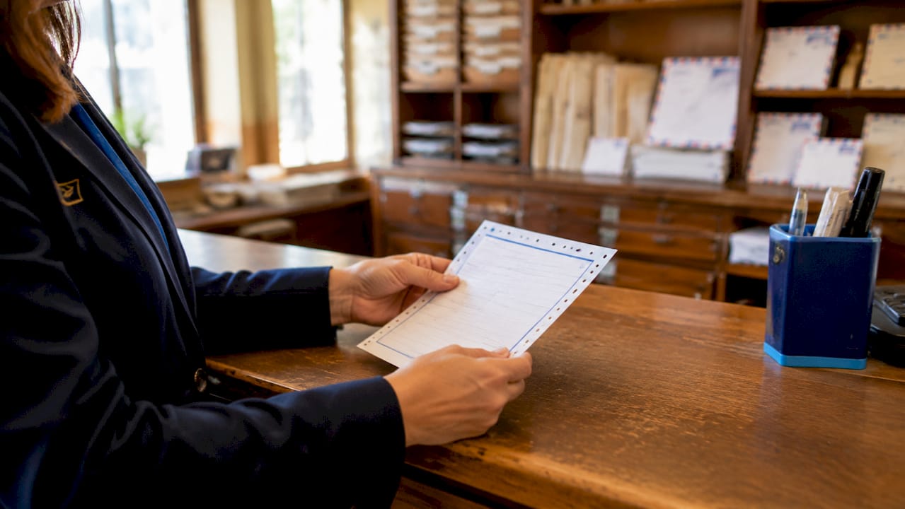 Close-up of postal clerk holding burofax receipt