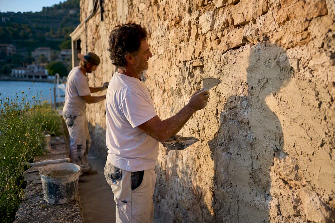 Craftsman applying lime mortar on stone