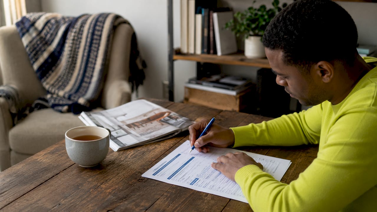 Hands marking credit score range on form at desk