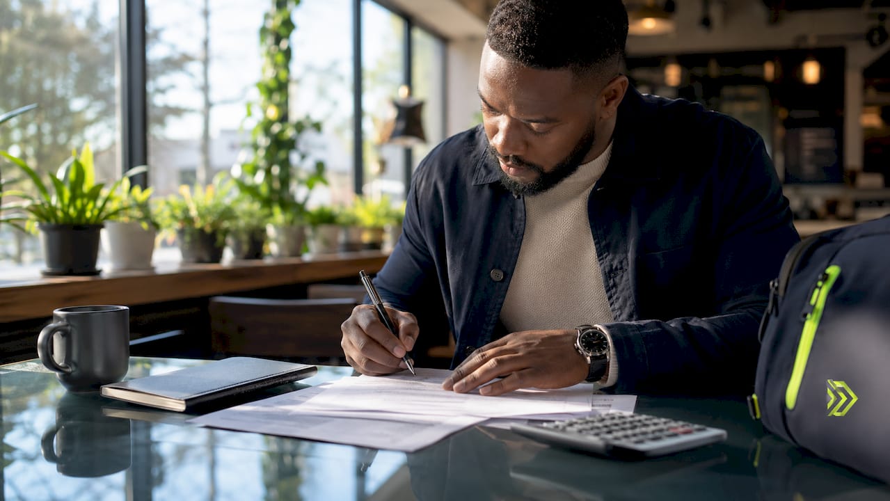 Hands reviewing mortgage paperwork with pen and calculator