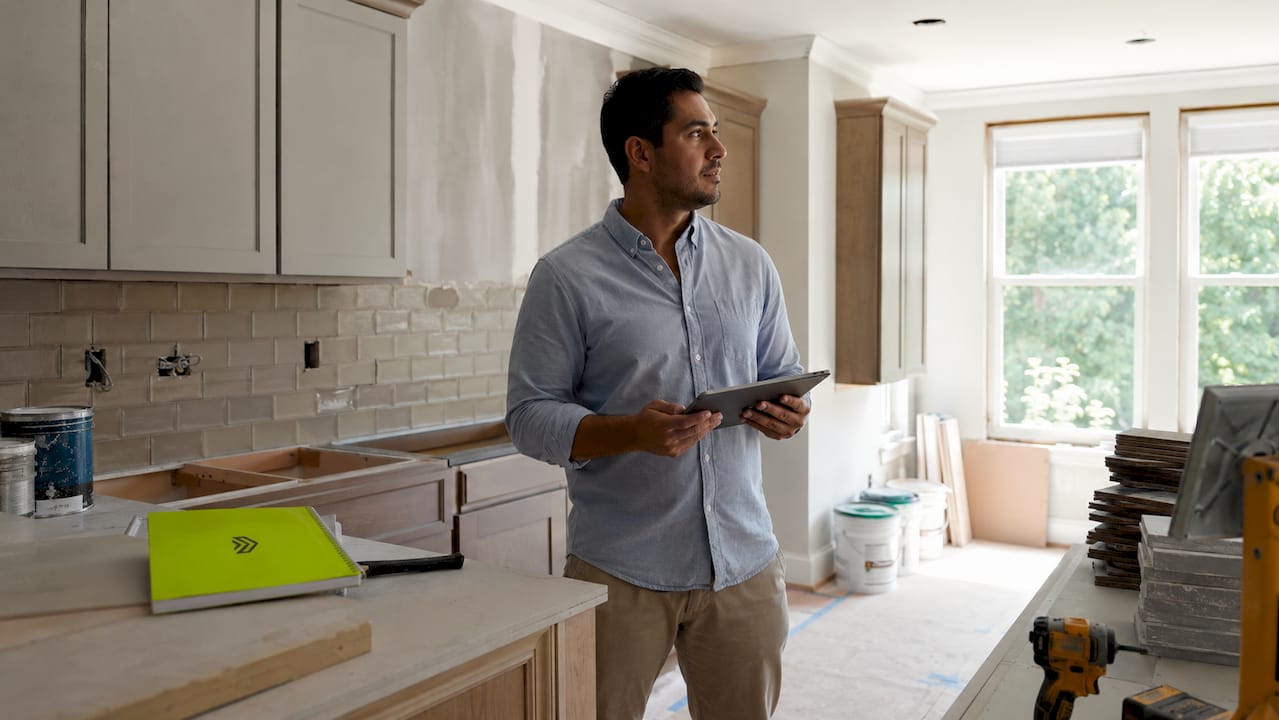 Man reviewing home renovation progress indoors