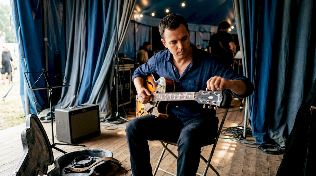 Hands tuning jazz guitar backstage