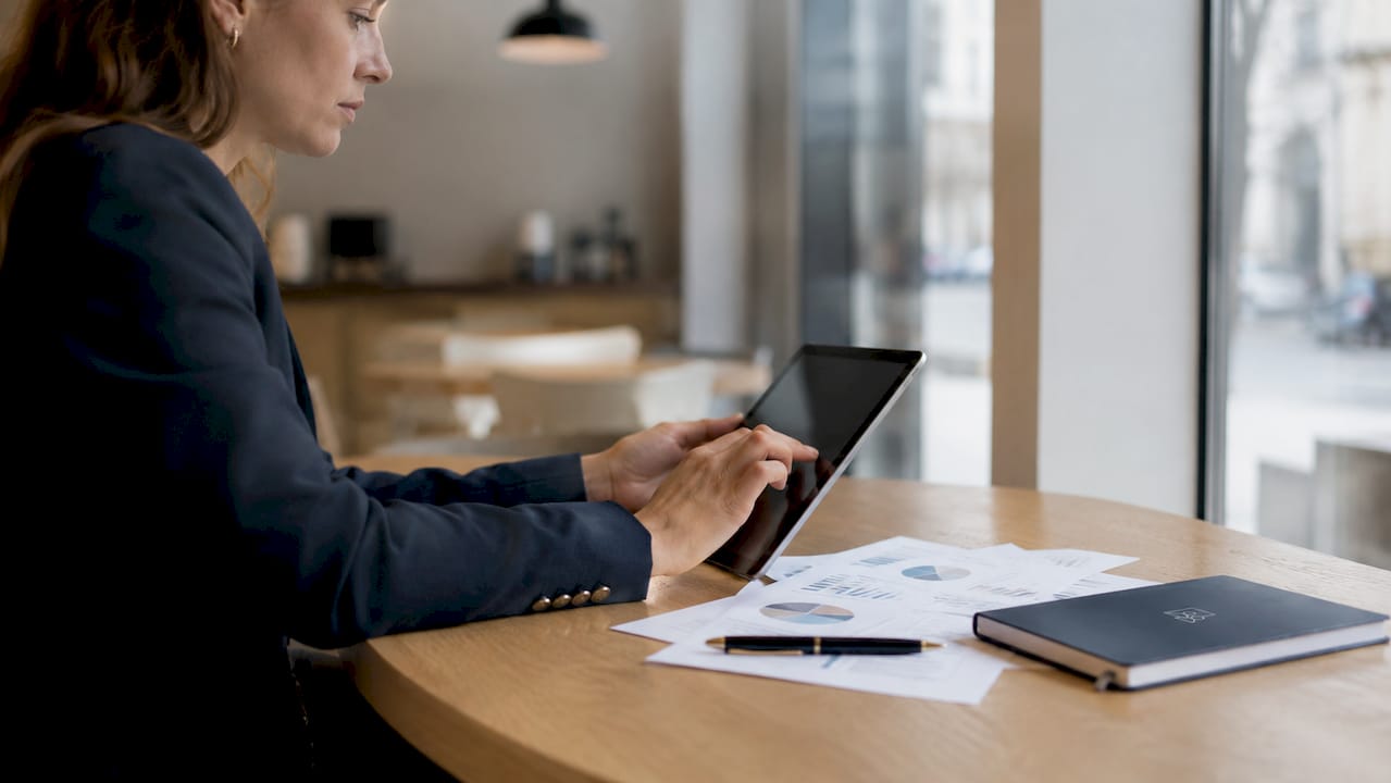 Une consultante RH utilise sa tablette pour gérer ses dossiers.